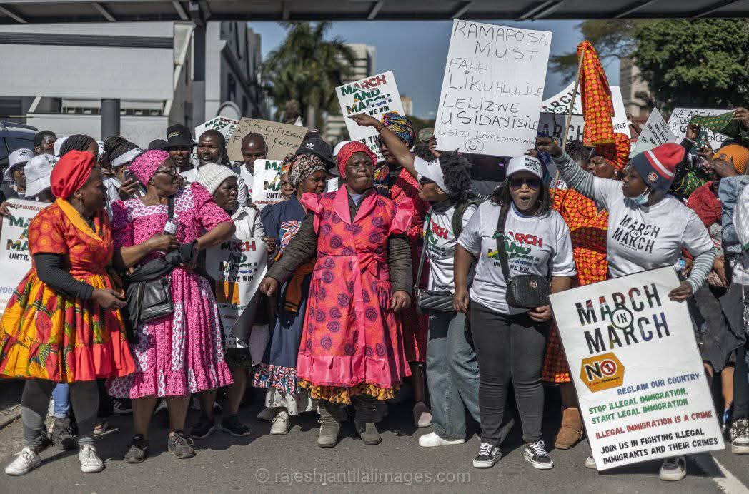 Community gathering wearing colorful traditional dress and March & March t-shirts